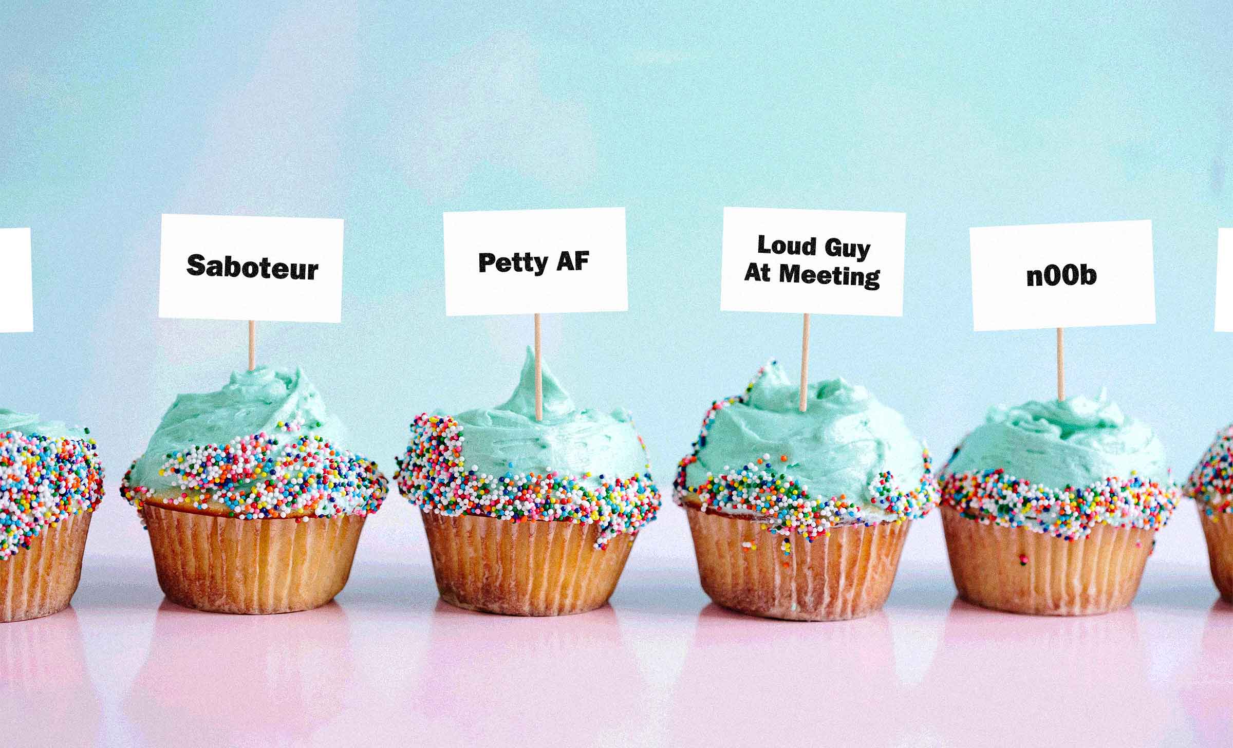 A line of cupcakes with little signs sticking out of them. The signs say, "Saboteur," "petty af," "loud guy at meeting," and "noob."