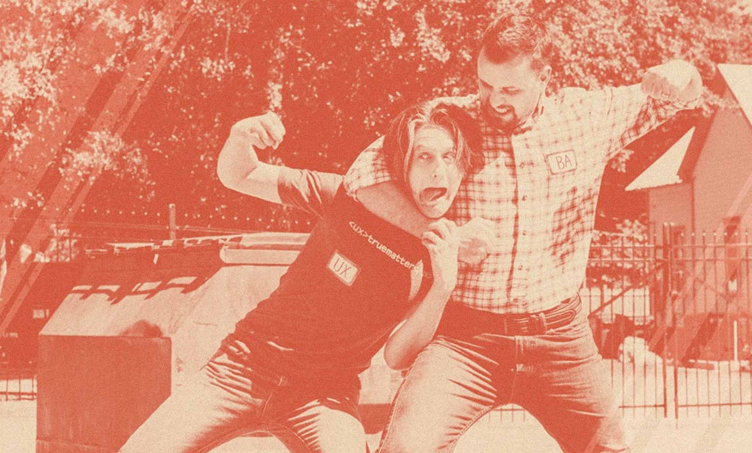 Two truematterians roleplaying as a business analyst and user experience play at fistfighting in a parking lot.