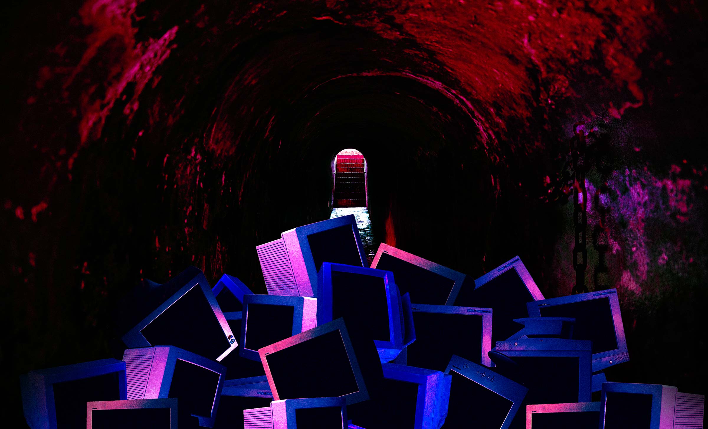 A dark dungeon containing a pile of dimly lit computers.