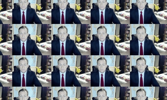 A looping image of a man with a serious expression in business attire. A child enters the room in the background.